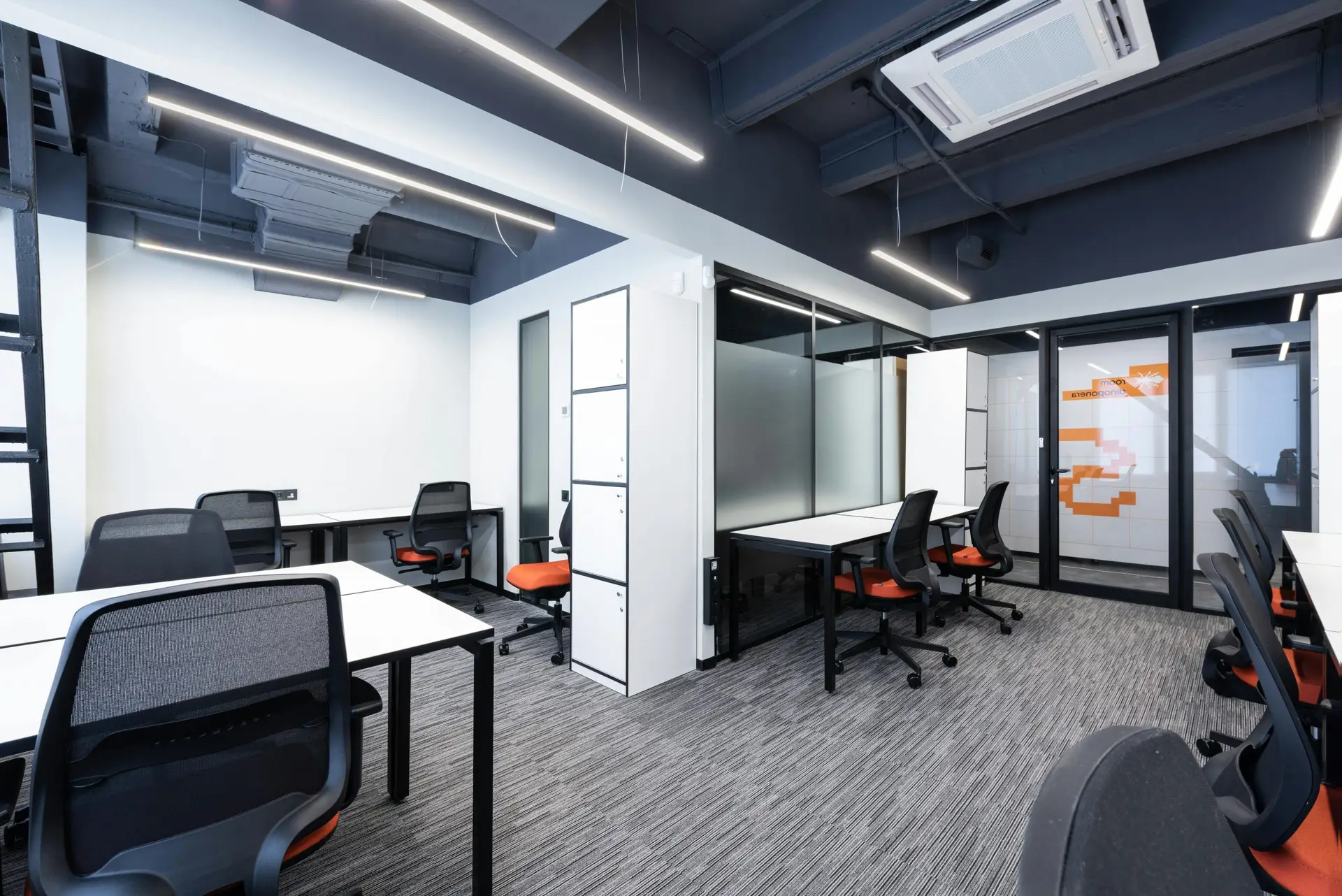 Spacious and modern office interior with sleek furniture and bright lighting.